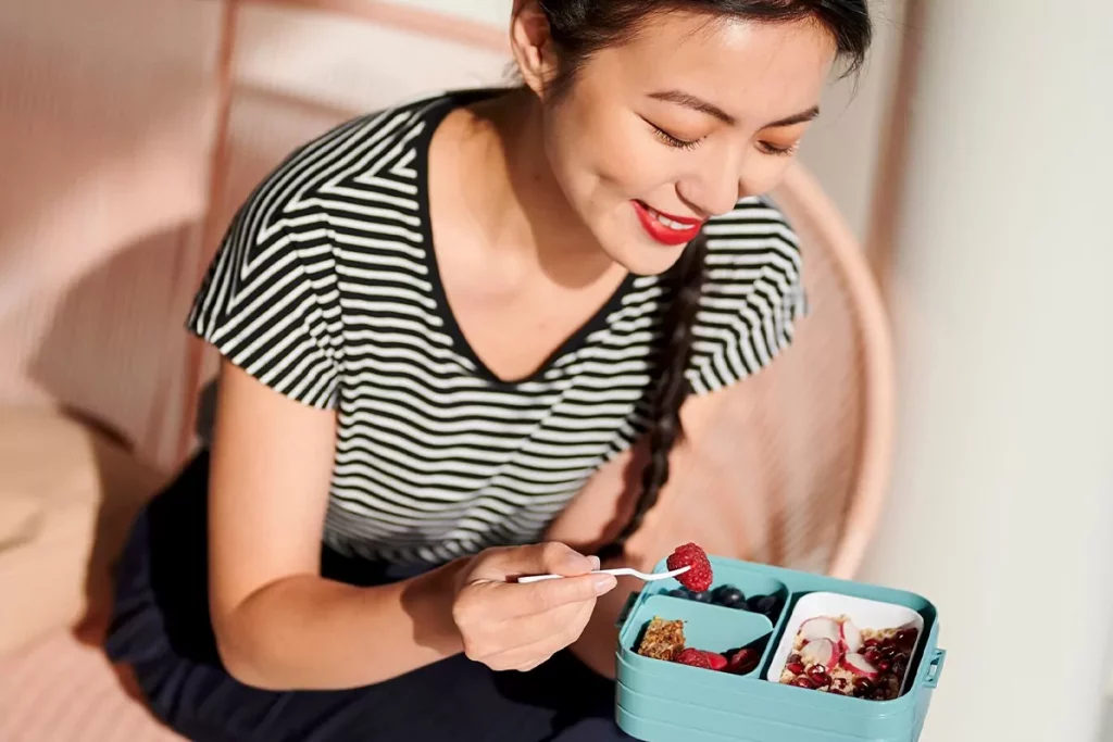 Frau genießt Mepal Bento Lunchbox mit Beeren und Snacks
